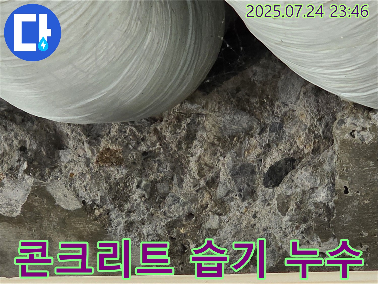콘크리트 습기 머금음 - 콘크리트가 습기를 머금어 어둡게 변색된 부분을 보여줍니다.
