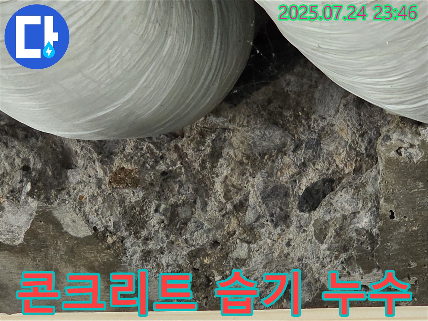콘크리트 습기 머금음 - 콘크리트가 습기를 머금어 어둡게 변색된 부분을 보여줍니다.