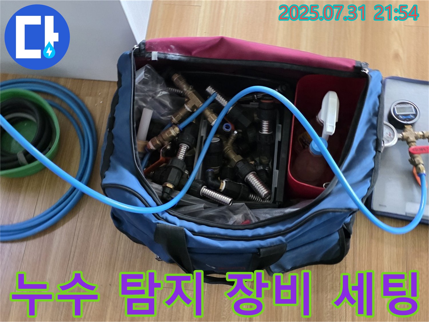 누수 탐지를 위한 장비 세팅 모습입니다 - 압력 점검을 위한 호스와 연결 부속들이 가지런히 놓여 있습니다.