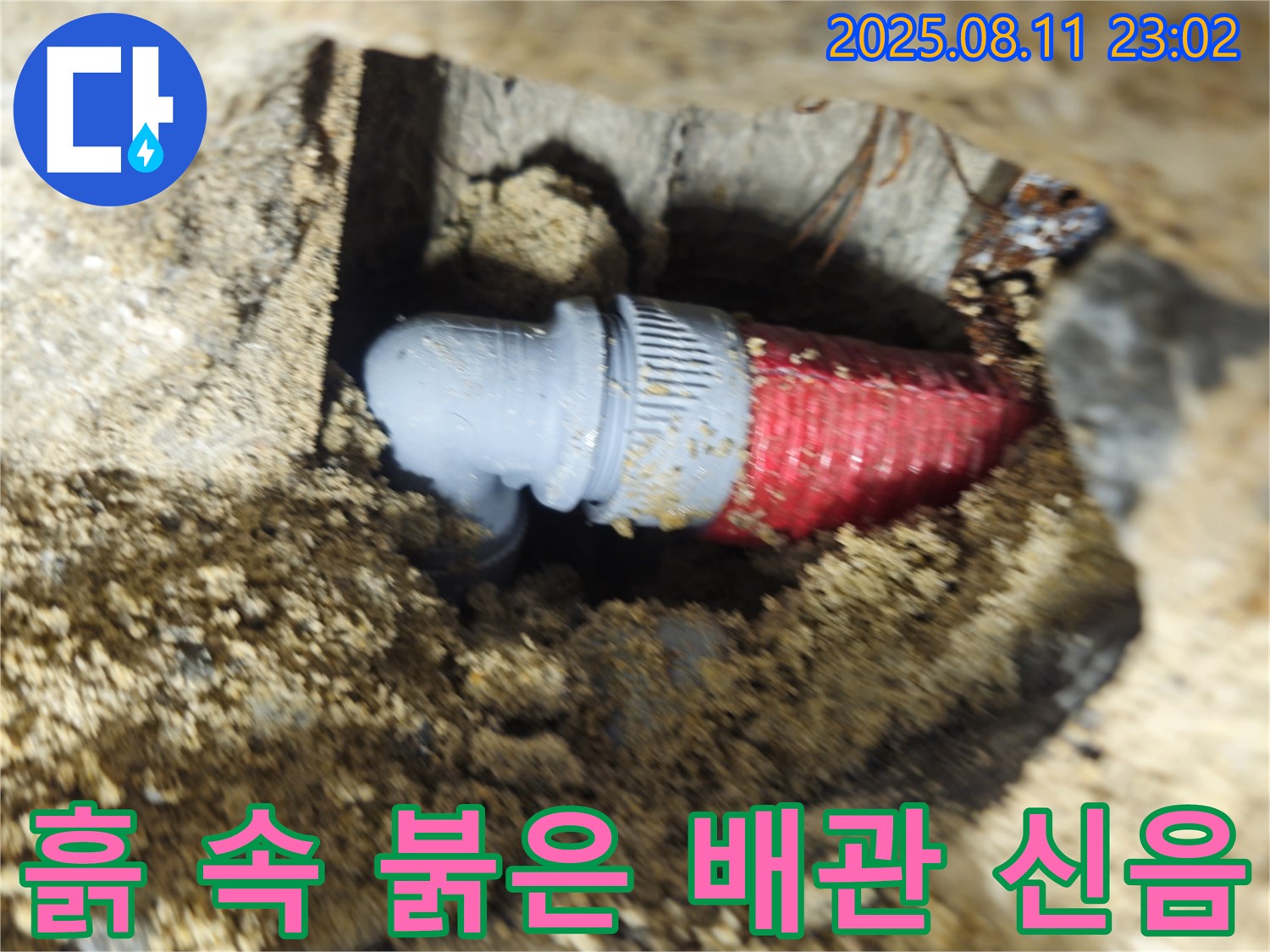 성북구 하월곡동 래미안 아파트 - 흙 속에 묻힌 붉은 배관에서 누수가 발생하여 마지막 신음을 내뱉는 듯합니다.