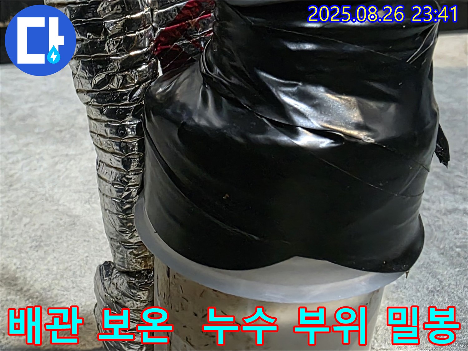 꼼꼼하게 보온재로 감싸고 검은 테이프로 밀봉된 배관 - 누수 재발 방지를 위한 세심한 조치입니다.