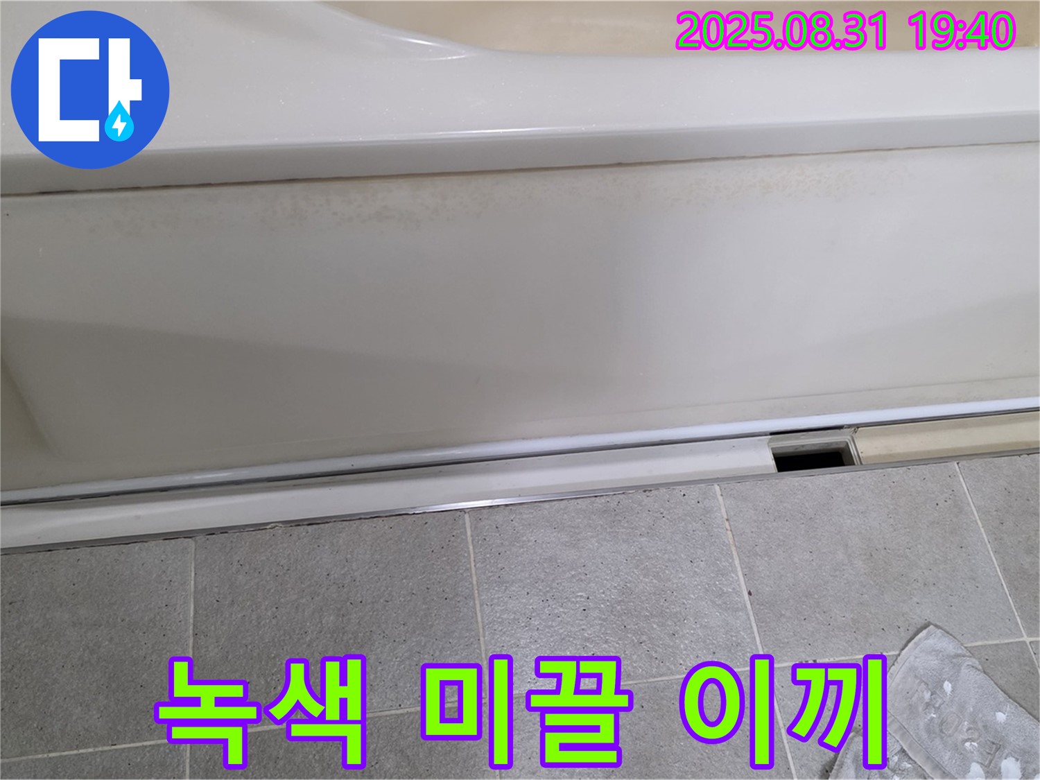산운마을 욕조 하단 누수 - 패널과 타일 사이 틈새에 물이끼 때문에 녹색으로 변색되고 미끌미끌한 상태입니다.