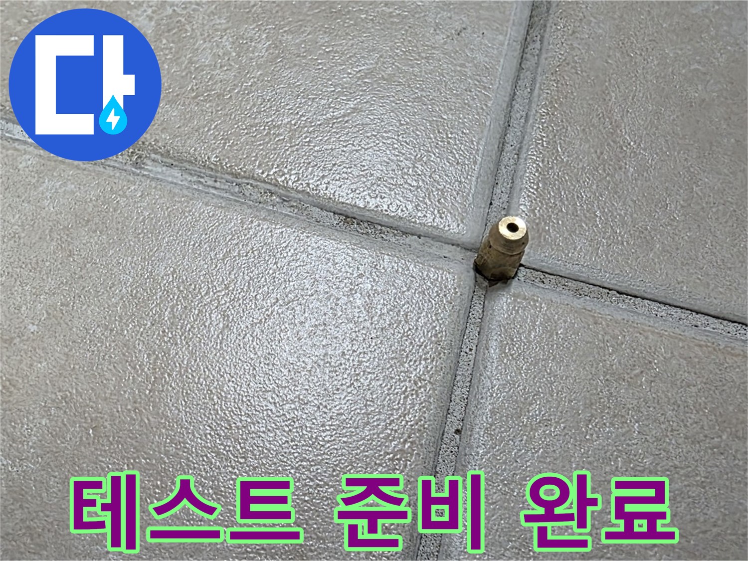 밝은 회색 타일 사이의 금속제 배관 연결 소켓