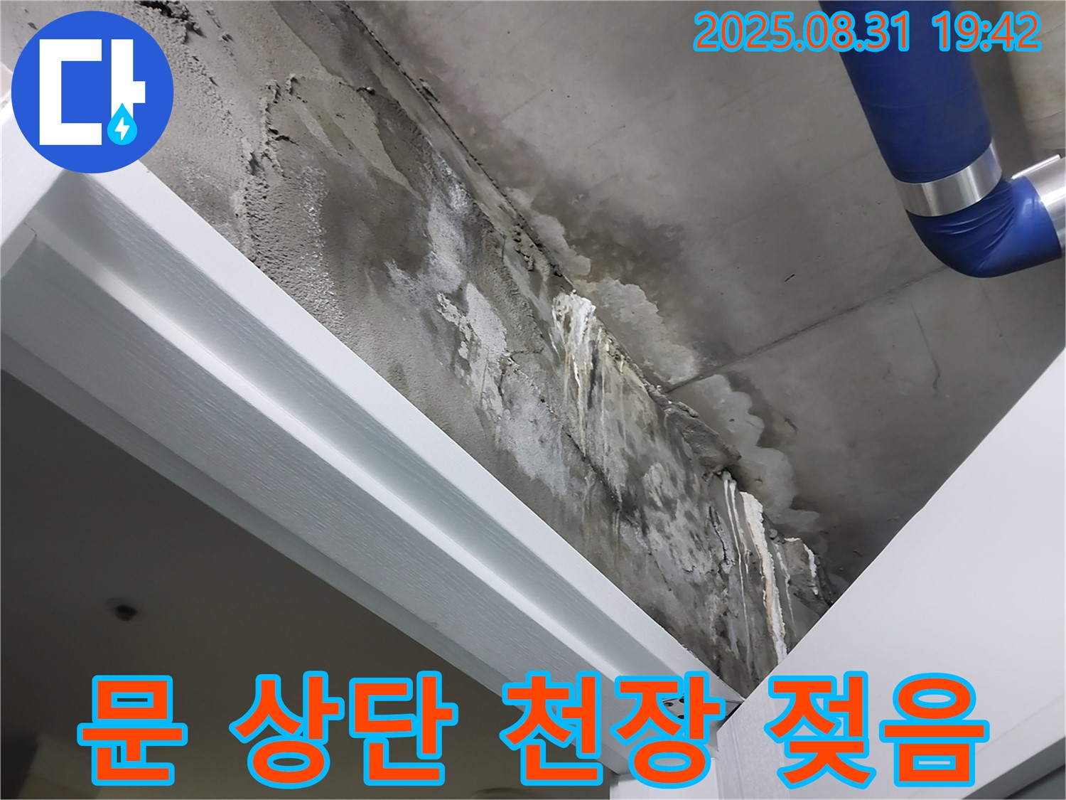 문 상단 - 천장 젖음 - 문 상단 천장에서 누수로 인해 천장이 젖어 있는 상태를 보여줍니다.
