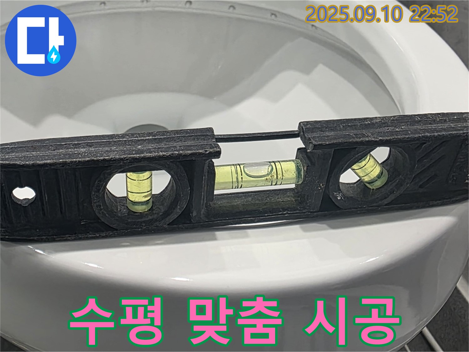 파주 동패동 수평 맞춤 시공 - 변기 누수 공사 중 수평계를 사용하여 변기의 수평을 맞추는 모습입니다.