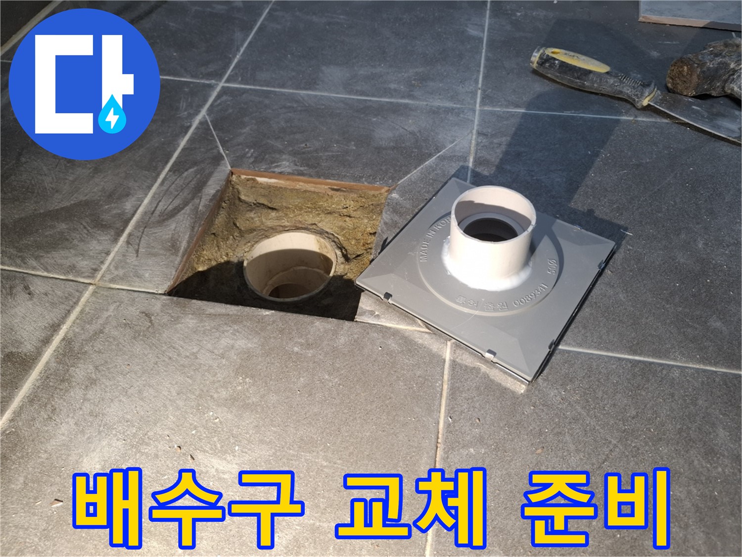 홍은빌라 배수구 교체 준비 - 새 배수구 설치를 위해 기존 배수구 주변을 점검하고 있습니다.