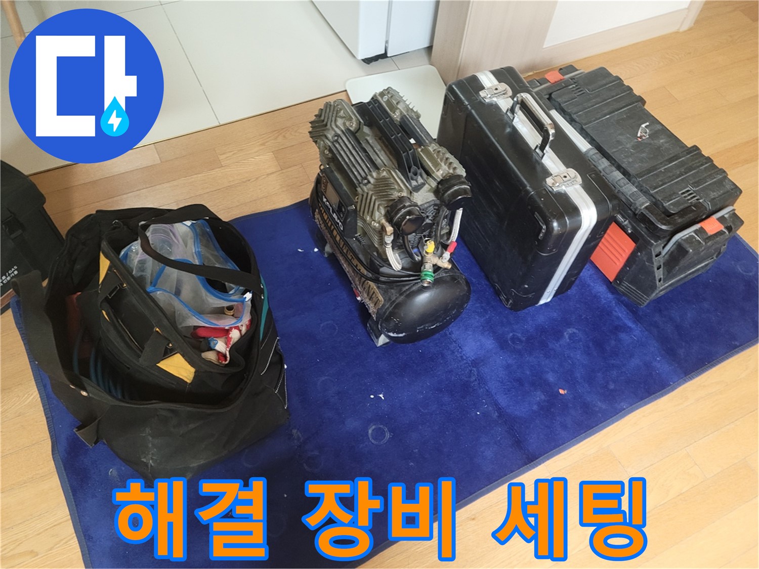 누수 해결을 위한 장비 세팅 - 콤프레셔, 공구 가방, 장비 케이스가 베테랑 엔지니어의 손길을 기다립니다.
