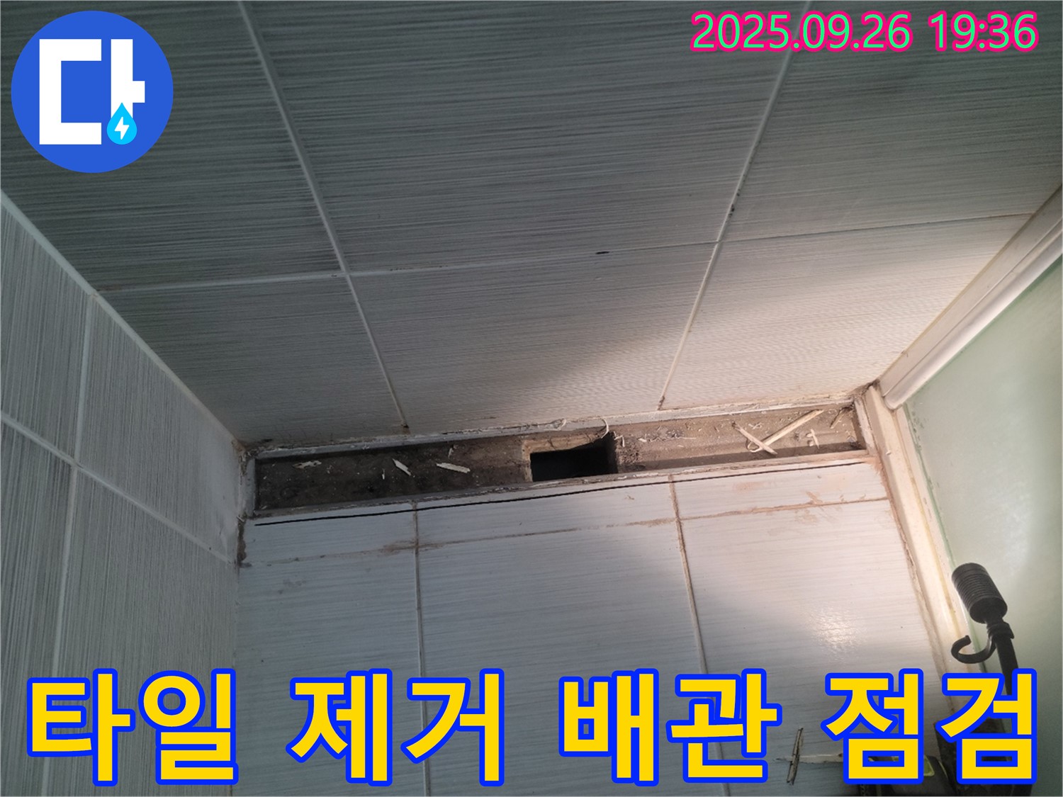 동두천 누수 공사 - 욕실 천장 타일 제거 후 배관 연결 부위를 점검하는 모습