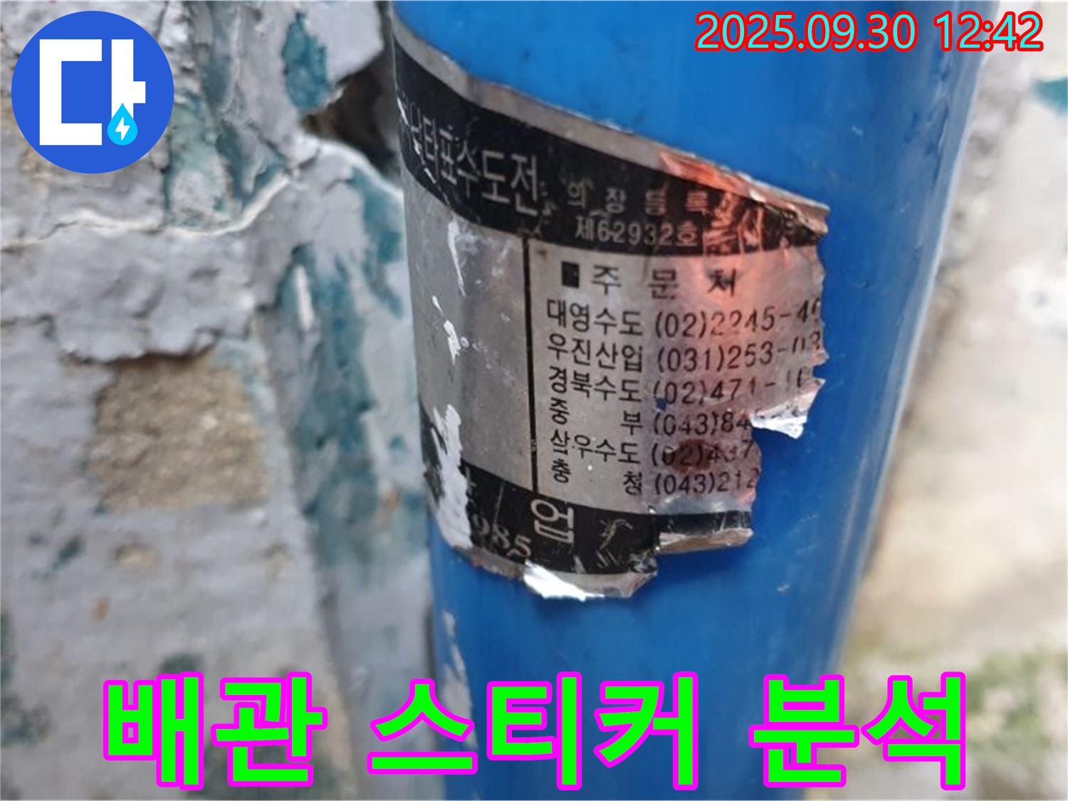 수도 배관에 부착된 오래된 스티커 - 시공 업체 정보와 함께 다양한 연락처가 기재되어 있습니다.