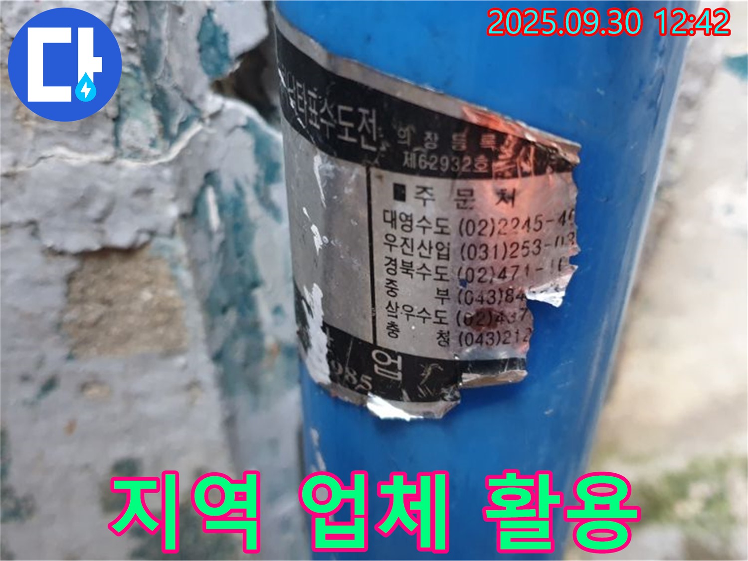 수도 배관에 부착된 오래된 스티커 - 지역별 시공 업체 정보와 함께 다양한 연락처가 기재되어 있습니다.