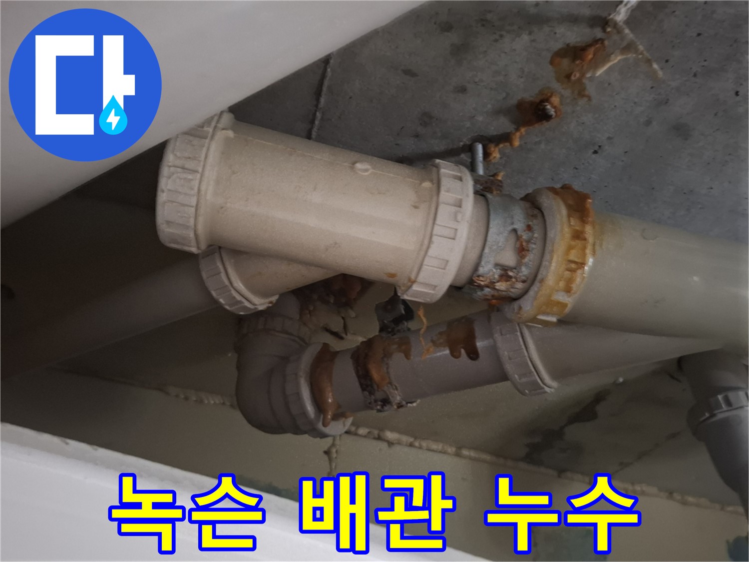녹슨 배관 누수 - 녹슨 하수 배관에서 물이 새어 나와 주변이 젖어 있는 모습입니다.