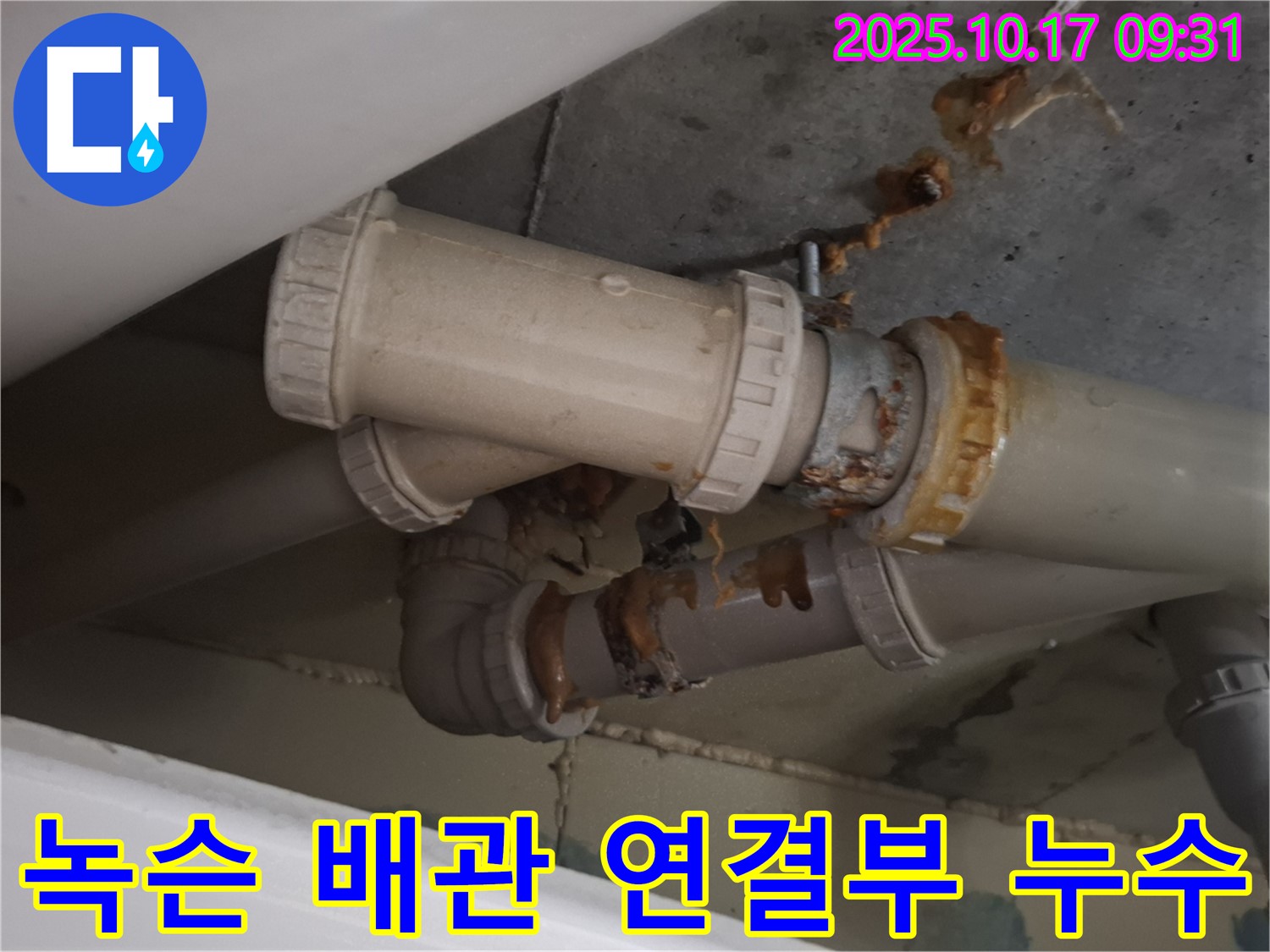 녹슨 배관 연결부 누수 - 배관 연결 부위가 심하게 녹슬어 누수가 발생하고 있습니다 - 즉시 보수가 필요합니다.