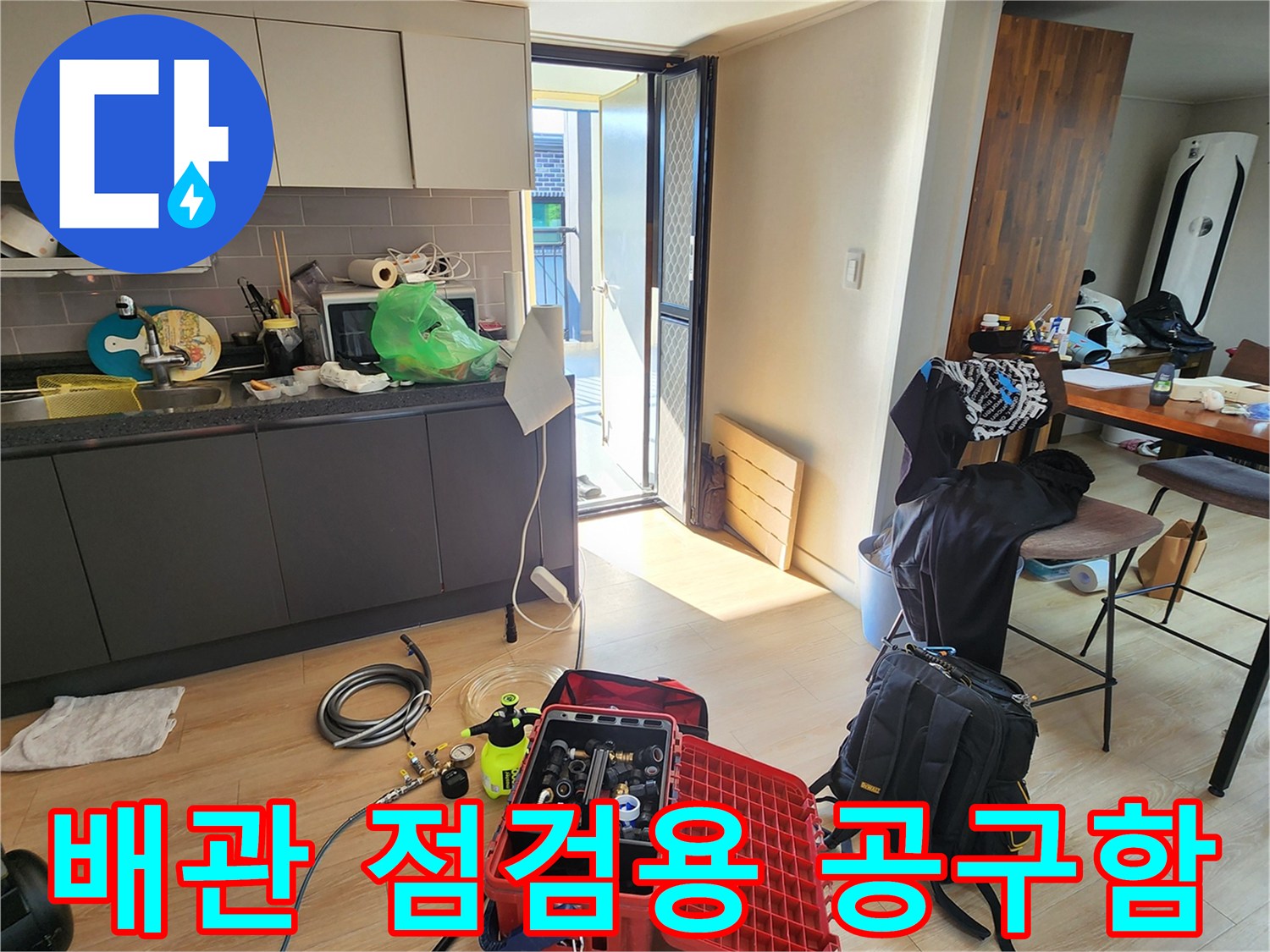 바닥에 펼쳐진 빨간색 공구 케이스와 누수 탐지용 호스 및 게이지