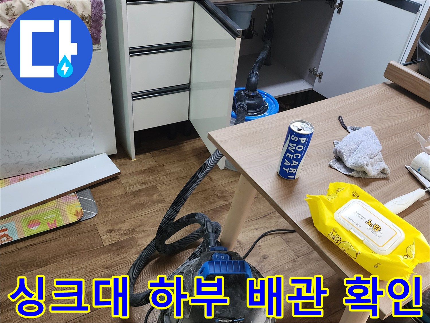 누수 지점 확인을 위해 개방된 싱크대 하단과 작업 도구