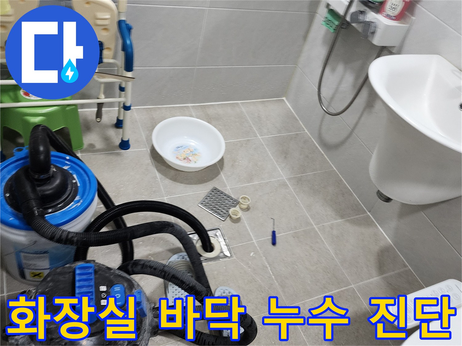 욕실 배수구 부품과 진단 장비가 놓여 있는 작업 현장 사진입니다.