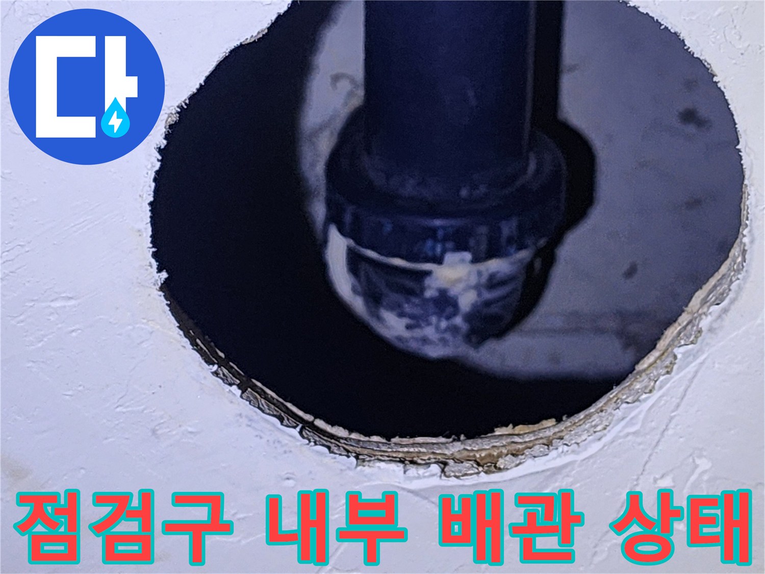어두운 점검구 안쪽으로 보이는 검은색 배관과 부속품 상세 모습