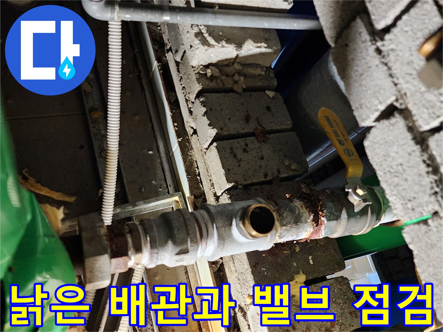 벽돌 구조물 내부에 노출된 부식된 배관 및 밸브