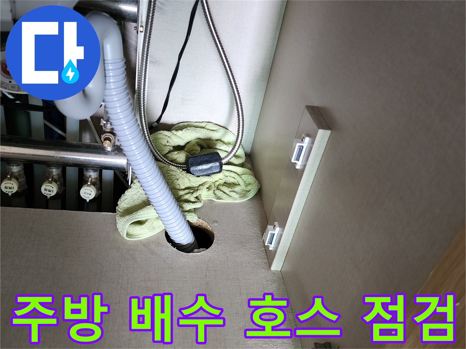 싱크대 하단 배수 호스와 주변 배관 부속들의 연결 상태를 보여줍니다.