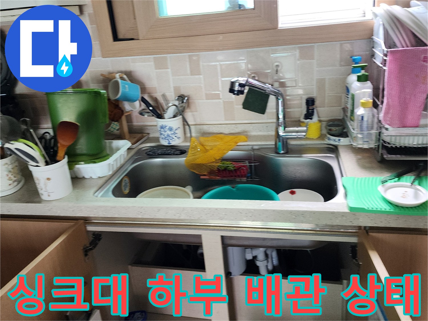 주방 싱크대 하부장 내부의 배관 및 연결 부위 점검 사진