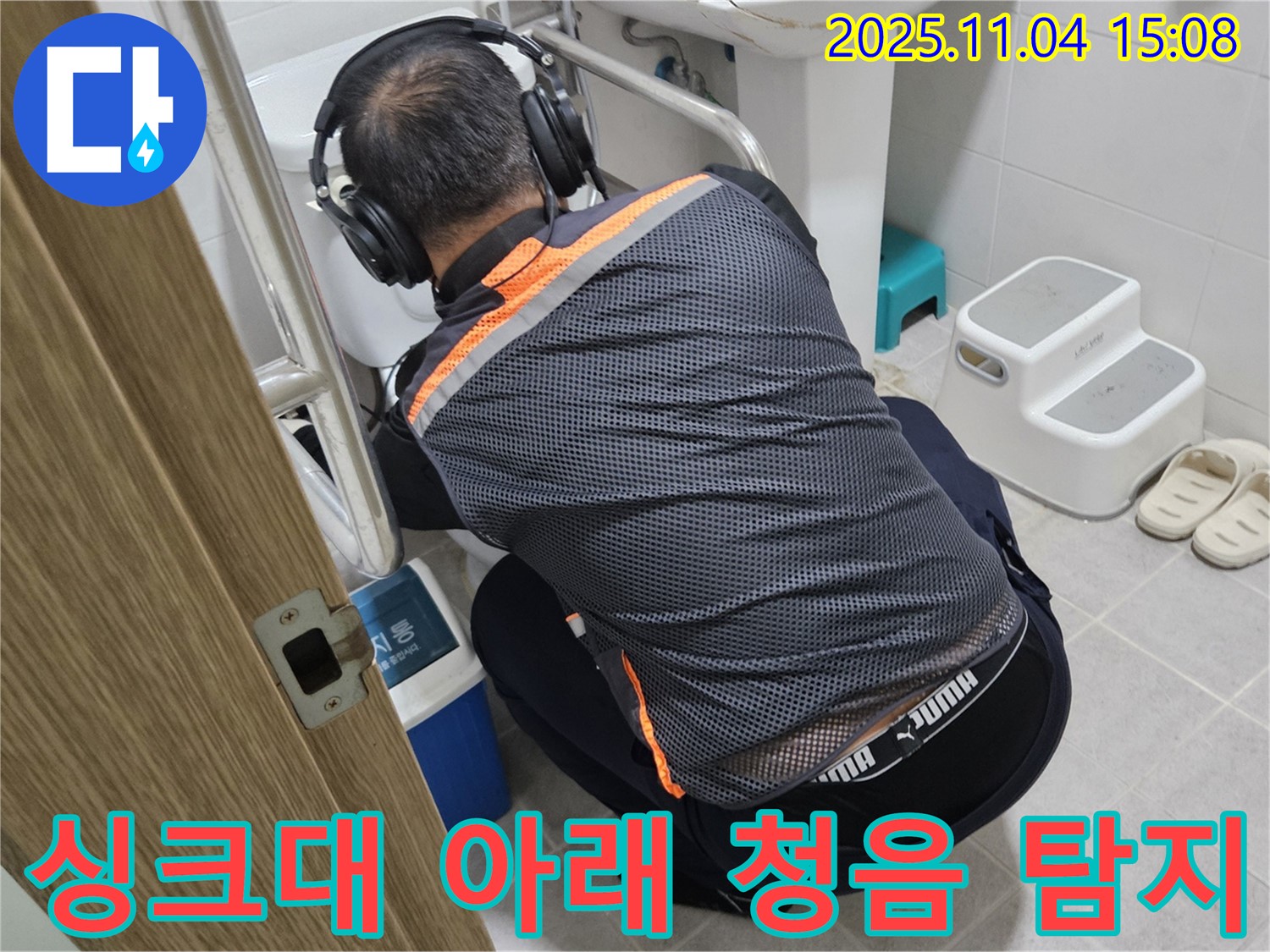누수 전문가가 싱크대 아래에서 청음 탐지 장비를 사용하여 누수 위치를 찾고 있습니다 - 꼼꼼한 점검으로 숨은 누수까지 찾아냅니다.