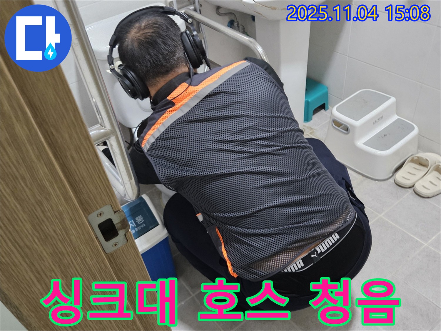 누수 전문가가 싱크대 호스 연결 부위에 청음 탐지 장비를 대고 누수 여부를 확인하고 있습니다 - 꼼꼼한 탐지로 숨은 누수까지 찾아냅니다.