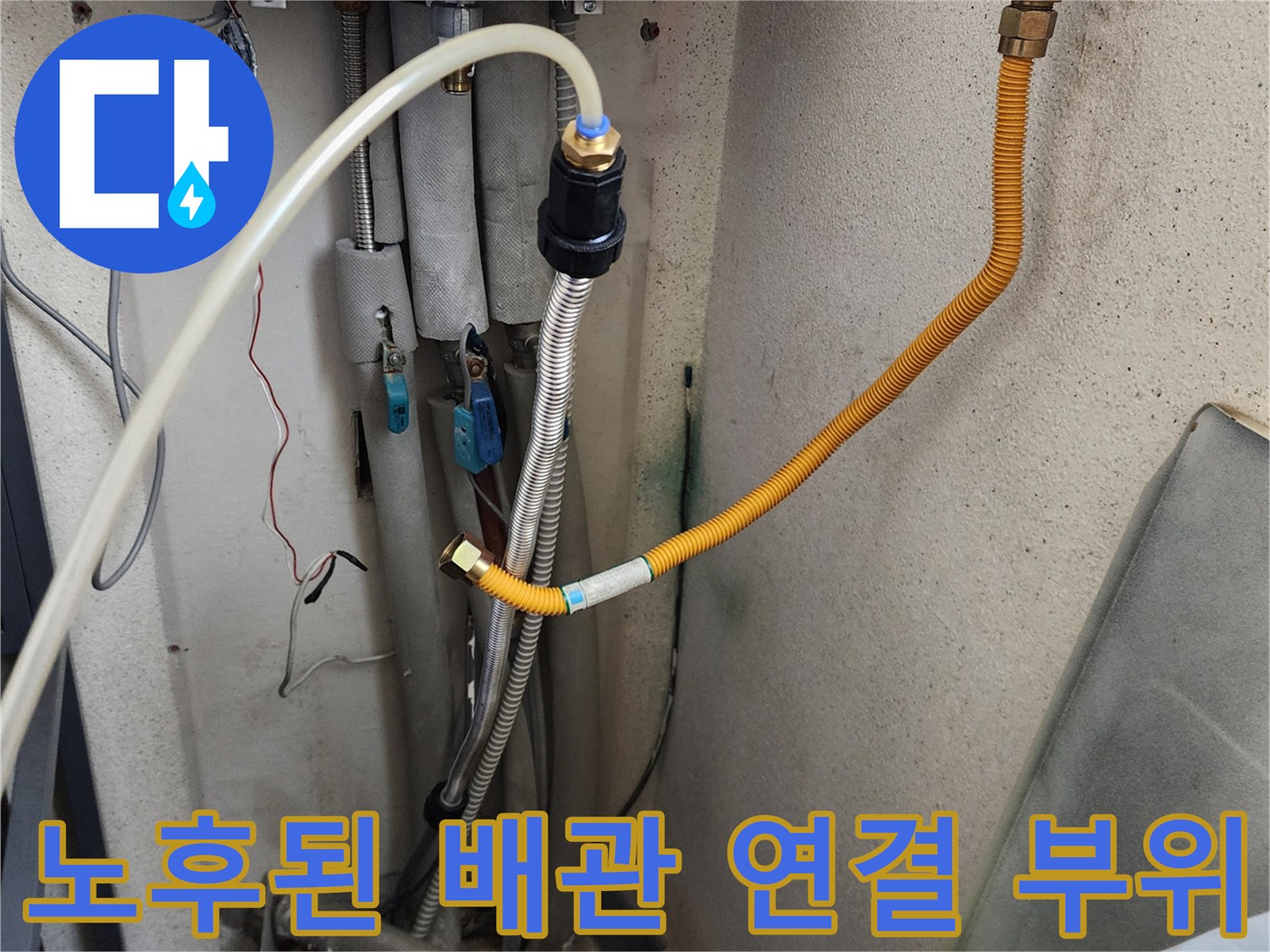 세탁실 벽면의 수도 밸브와 연결 호스들의 노후 상태를 나타내는 이미지입니다.