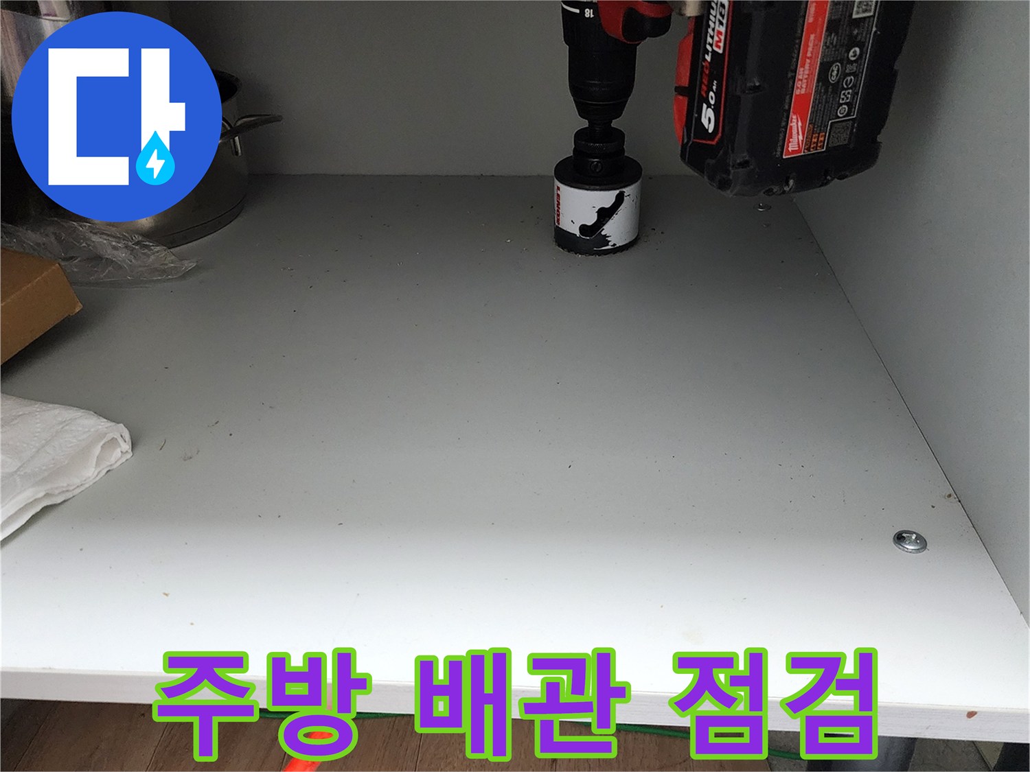 싱크대 내부 선반과 작업용 드릴의 근접 촬영