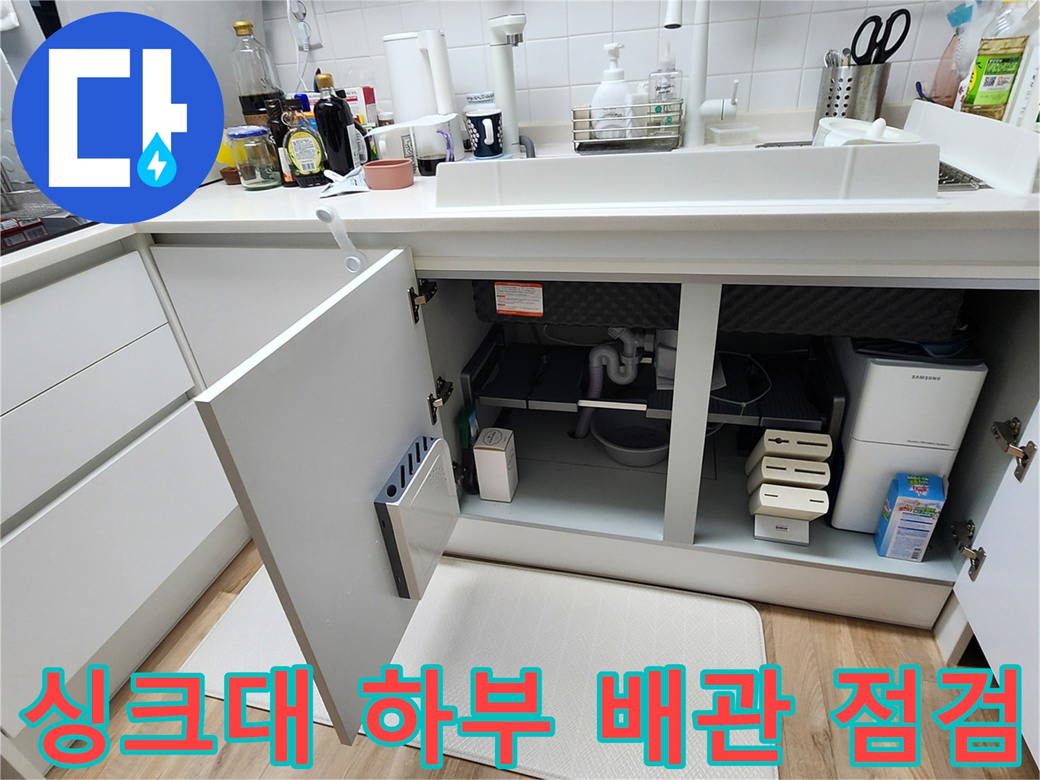 싱크대 아래쪽 하부장 내부의 배관 구조와 주변 환경 촬영