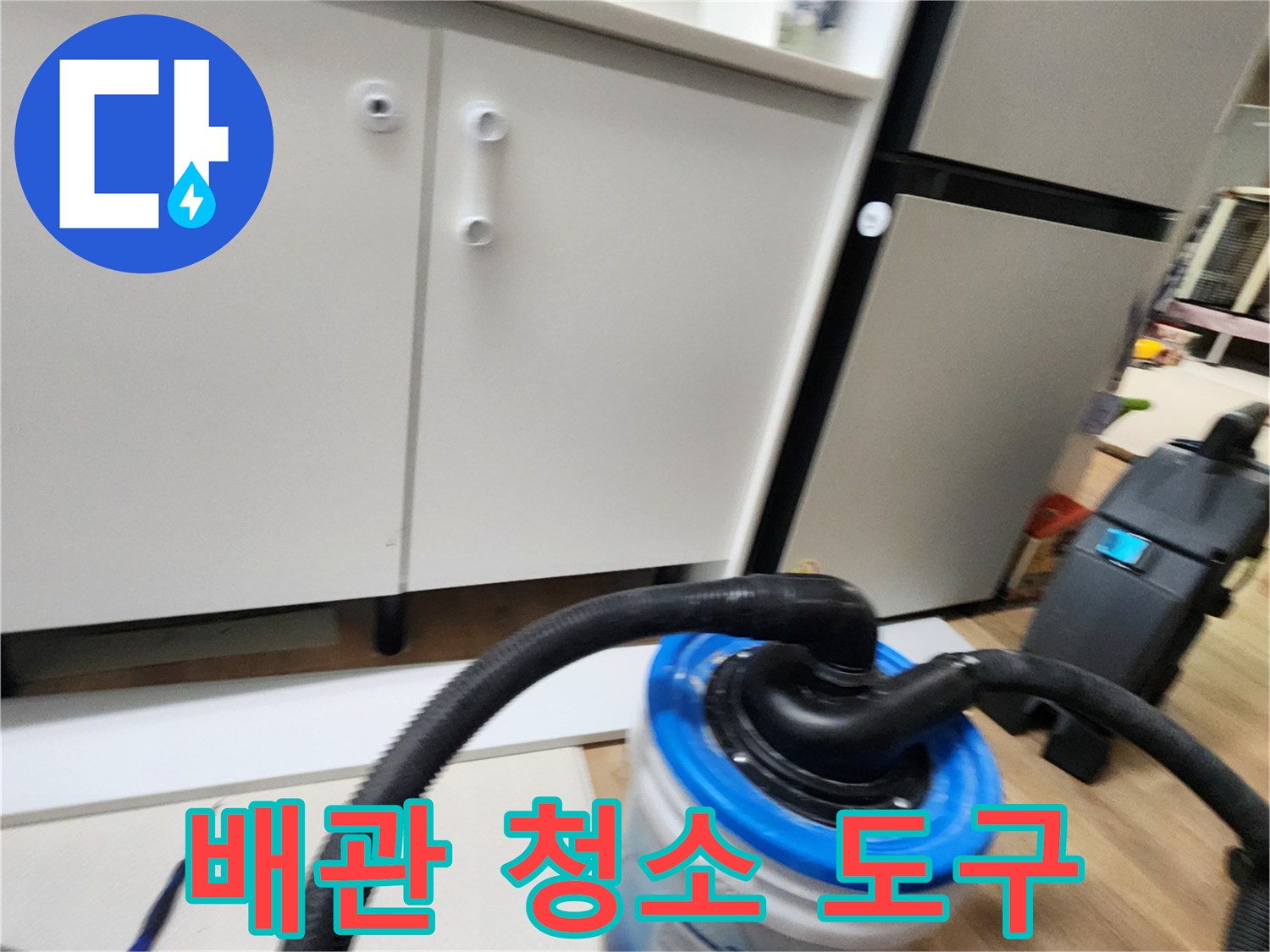 싱크대 하단 배관 세척을 위한 흡입 장비와 양동이 모습