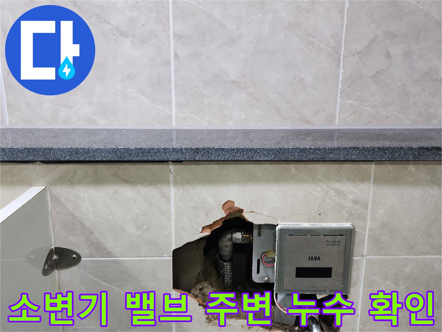 상가 화장실 타일 내부의 소변기 밸브와 노출된 배관 부위입니다.