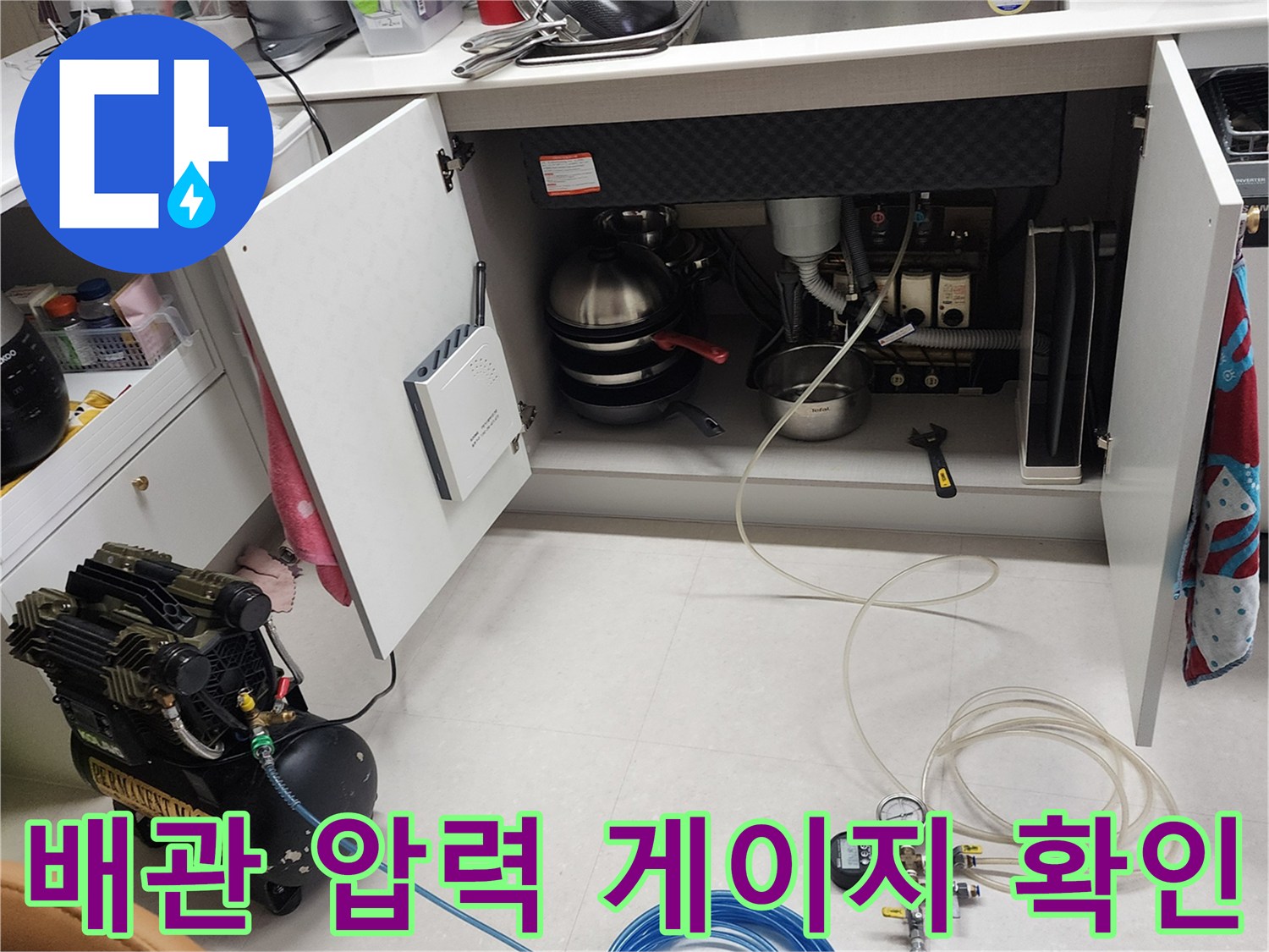 누수 탐지를 위한 공압 장비-싱크대 하부 배관에 연결된 압력계와 호스 모습입니다.