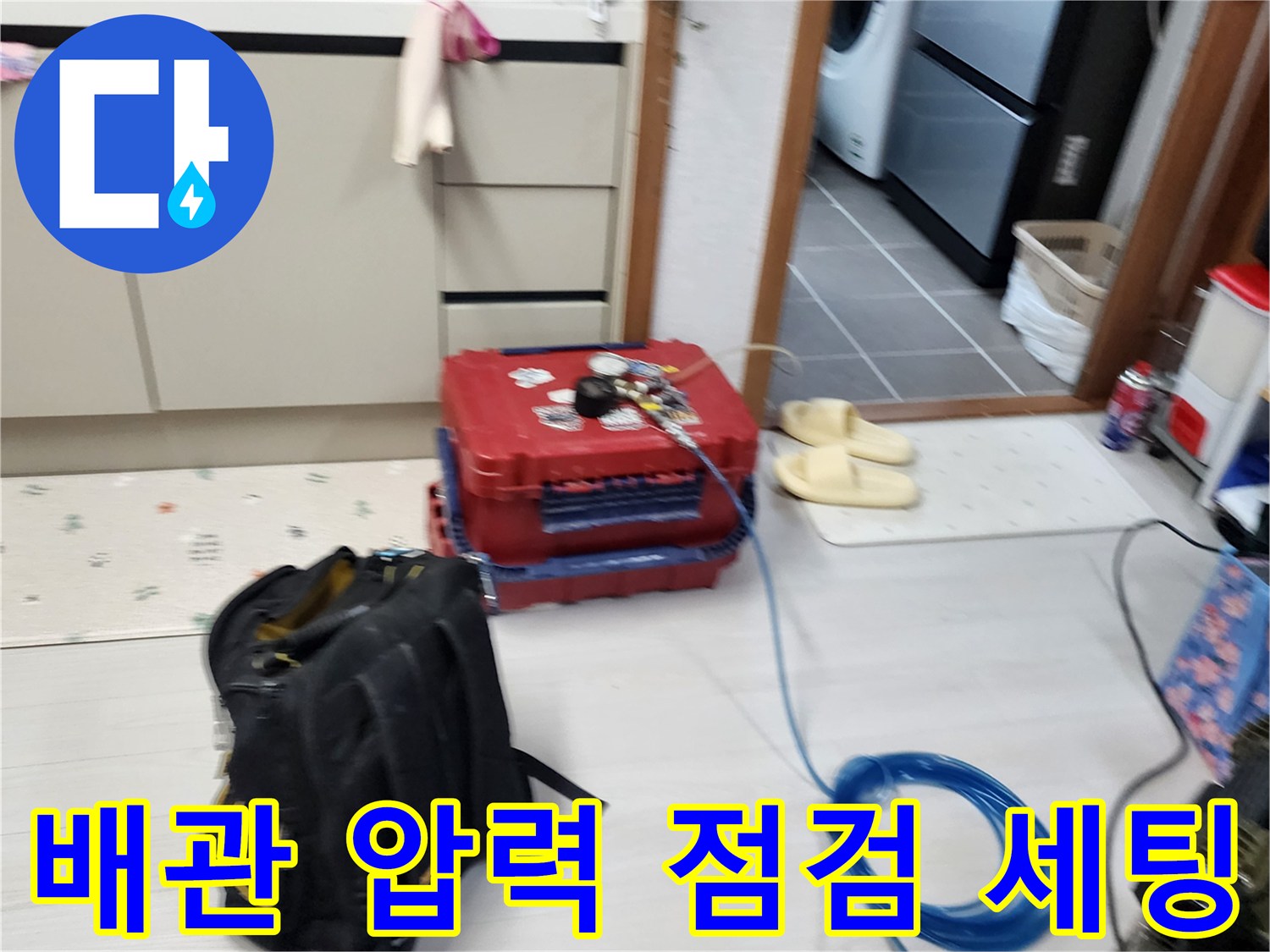 주방 바닥에 설치된 누수 탐지용 공압 테스트기 및 호스 연결 모습