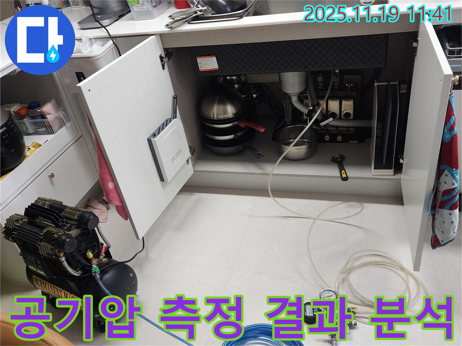 포천 내촌 누수 현장 - 싱크대 하부에서 공기압 측정 결과를 꼼꼼하게 분석하는 모습입니다.