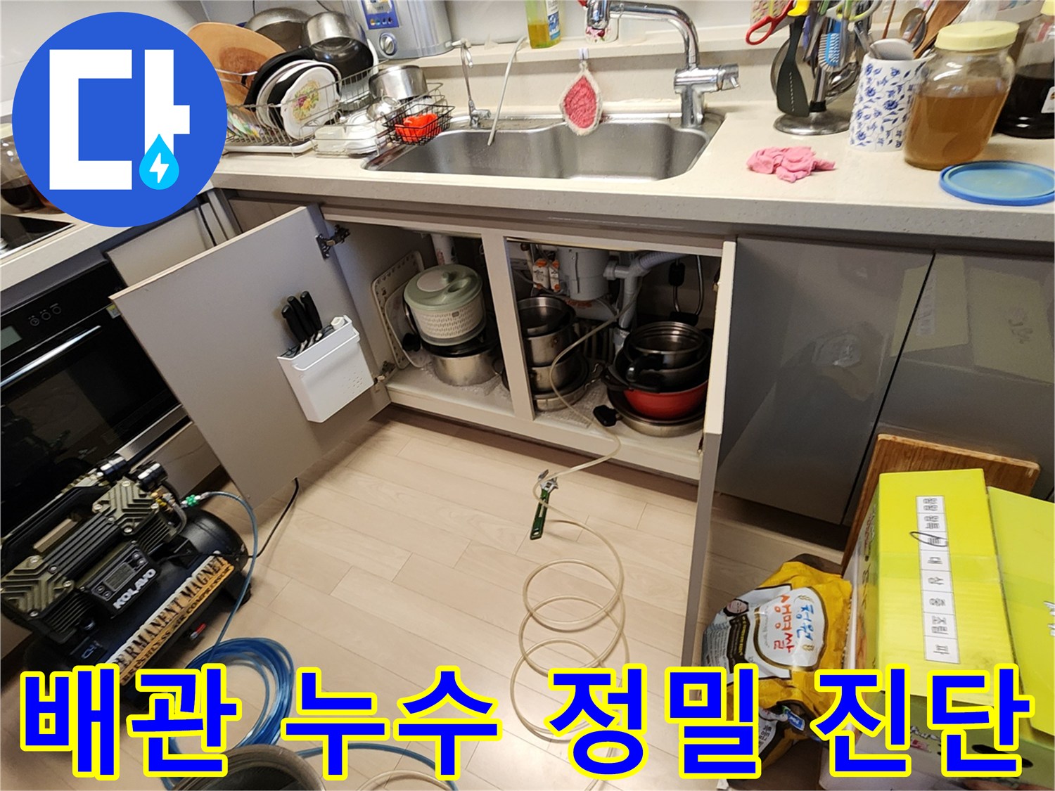싱크대 하부 배수 호스와 압력 장비 연결 모습