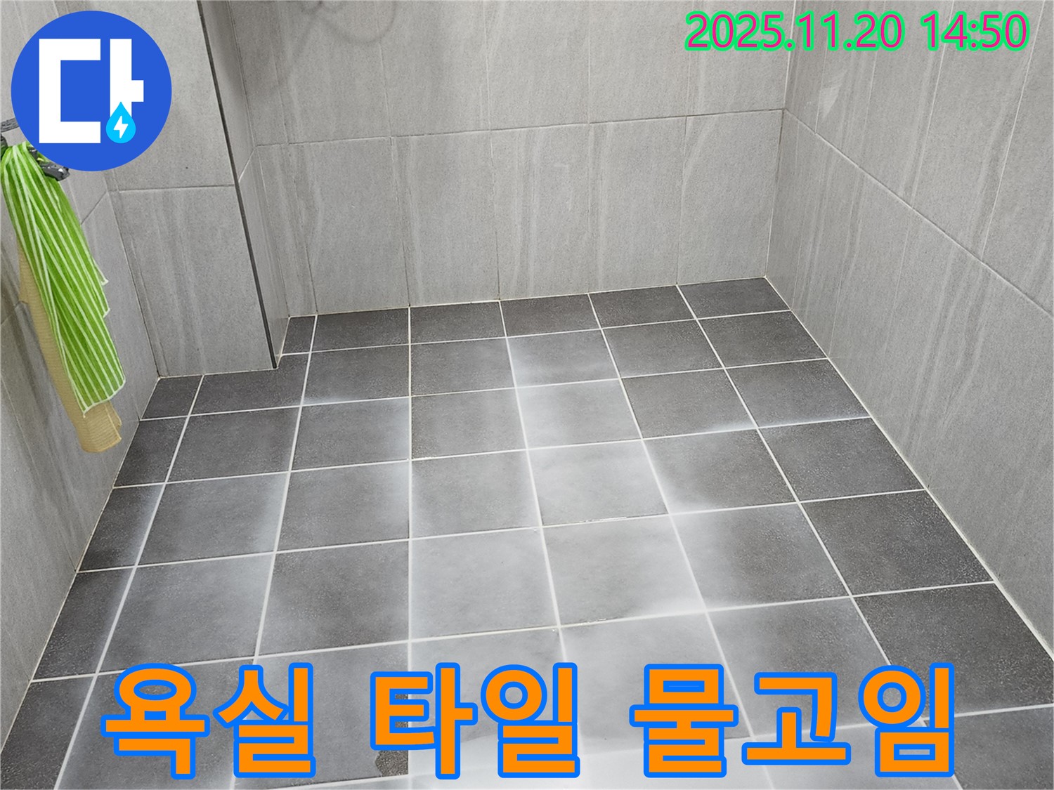 욕실 바닥 타일에 물이 고여있는 모습 - 미끄럼 사고 위험과 누수 가능성을 보여줍니다.
