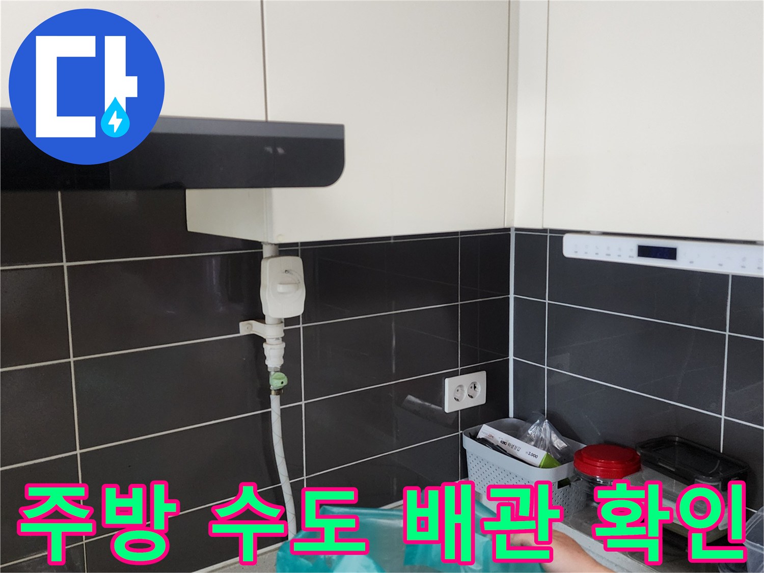 싱크대 하부의 급수 배관과 벽면 콘센트 부위 사진