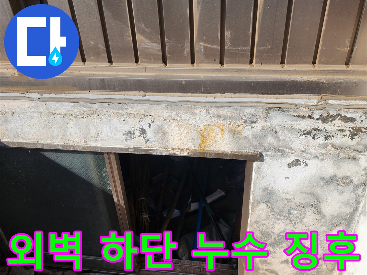 건물 외벽 하단의 노란 얼룩과 습기가 머무른 흔적 사진