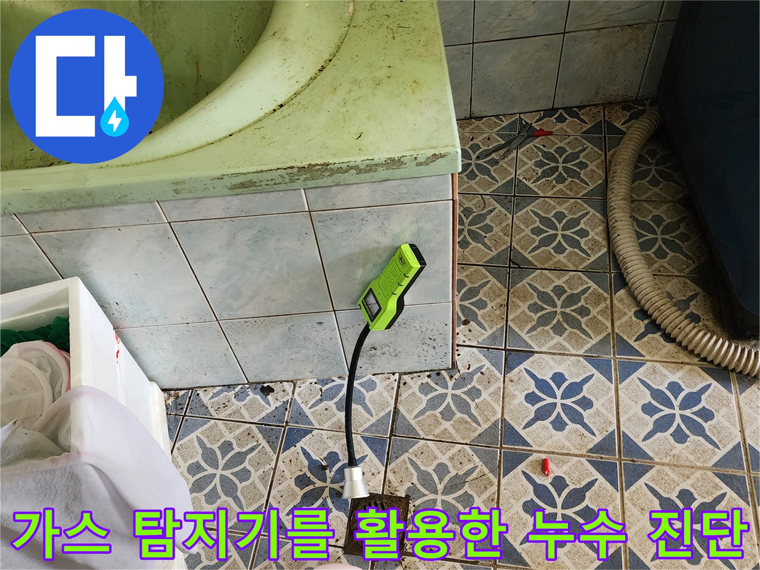욕실 바닥 타일 사이에서 작동 중인 초록색 가스 탐지기