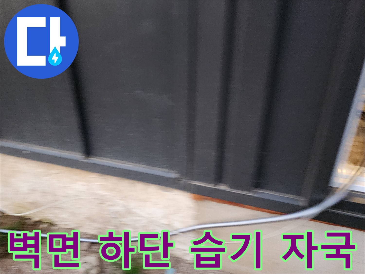 건물 외벽 패널 하단의 젖어 있는 콘크리트 노출 부위