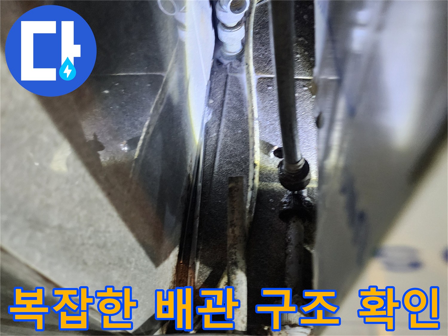 주방 하부의 젖어 있는 배관과 연결 소켓 부위 상세 이미지