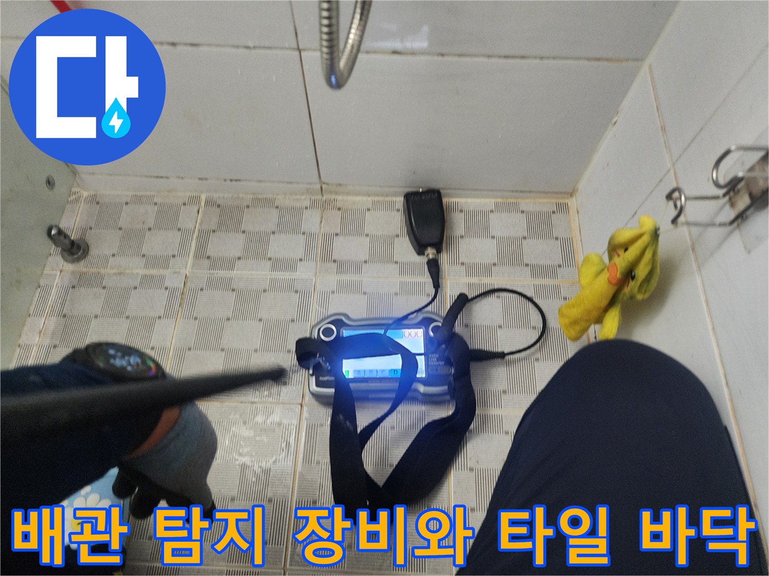 타일 바닥에 배치된 가스식 배관 탐지 장비와 점검용 센서의 모습입니다.