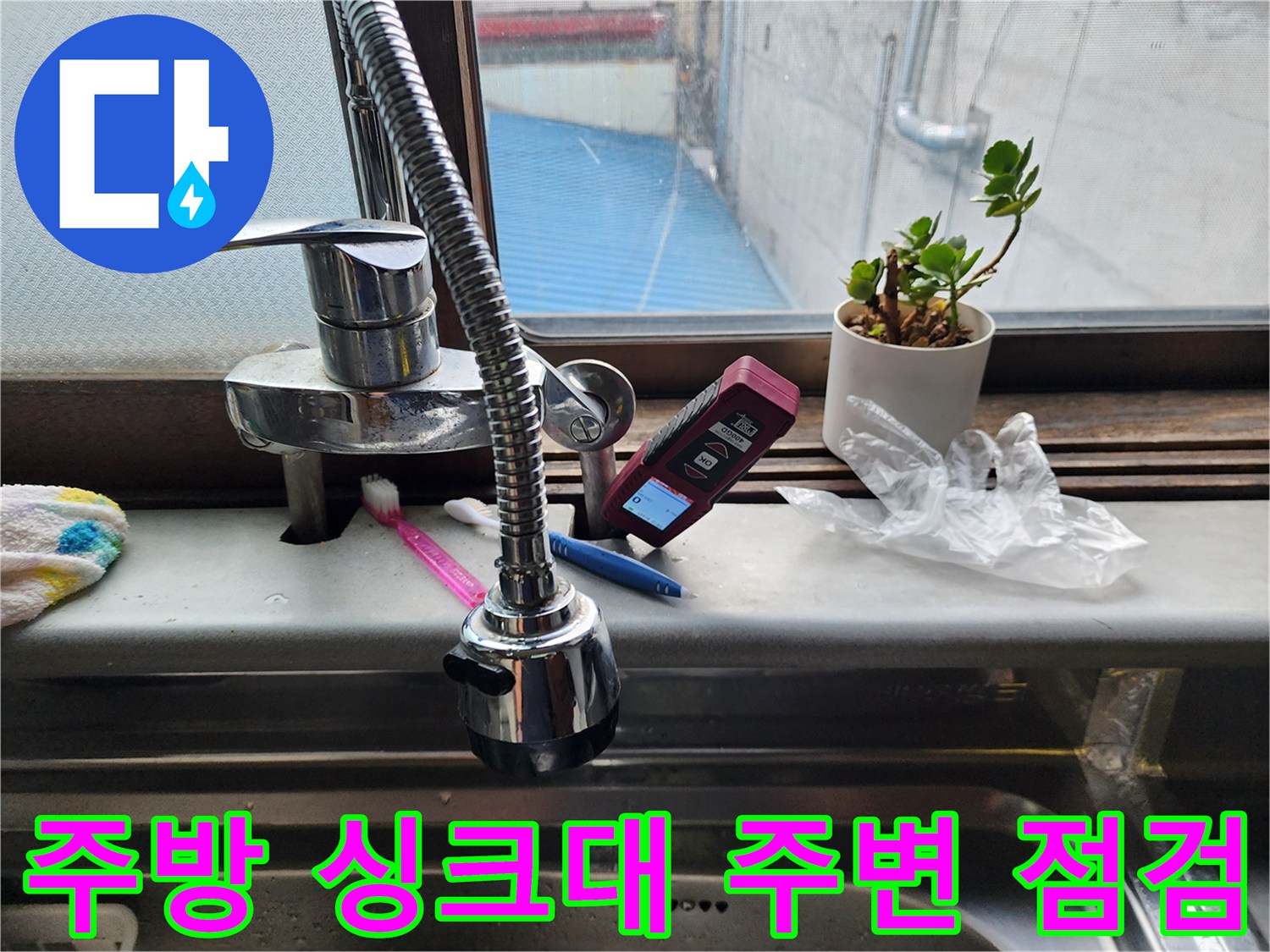 싱크대 수전 옆에 놓인 휴대용 누수 탐지 장비와 화분
