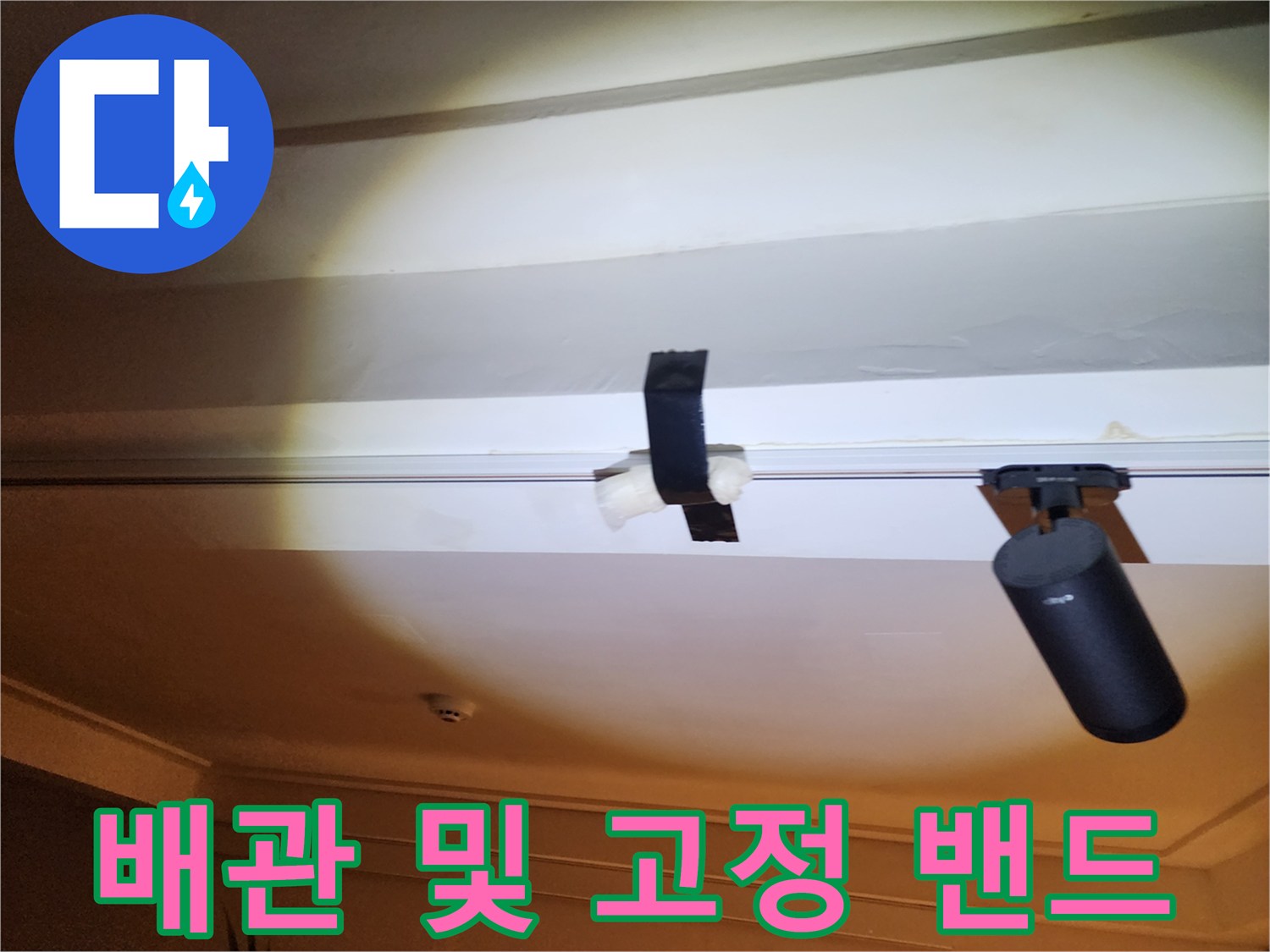 천장에 설치된 배관과 검은색 고정 밴드 모습입니다.