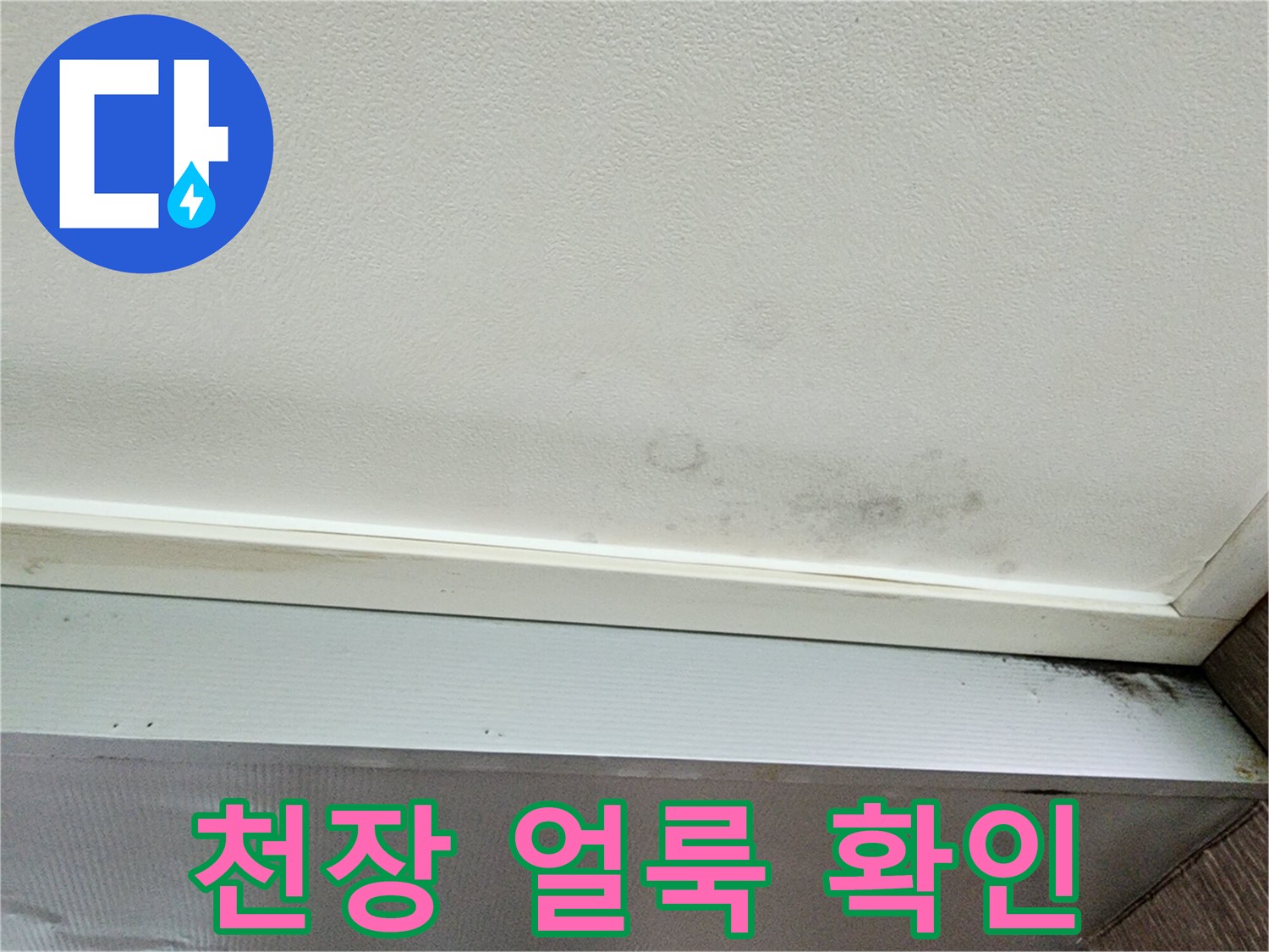 누수로 인해 어둡게 변한 천장 벽지 경계 부위
