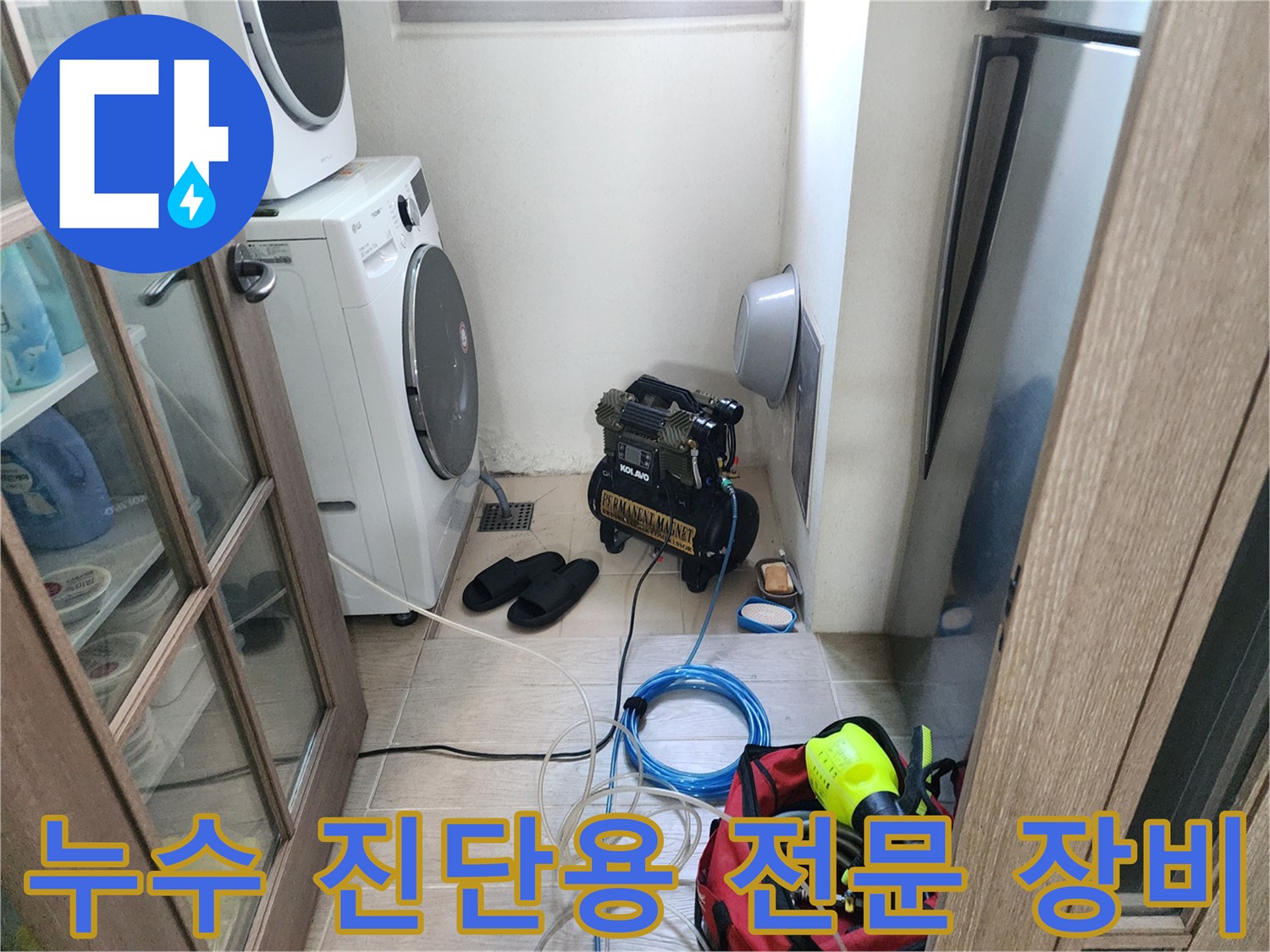 세탁실 바닥에 배치된 배관 탐지기와 전동 공구 세트