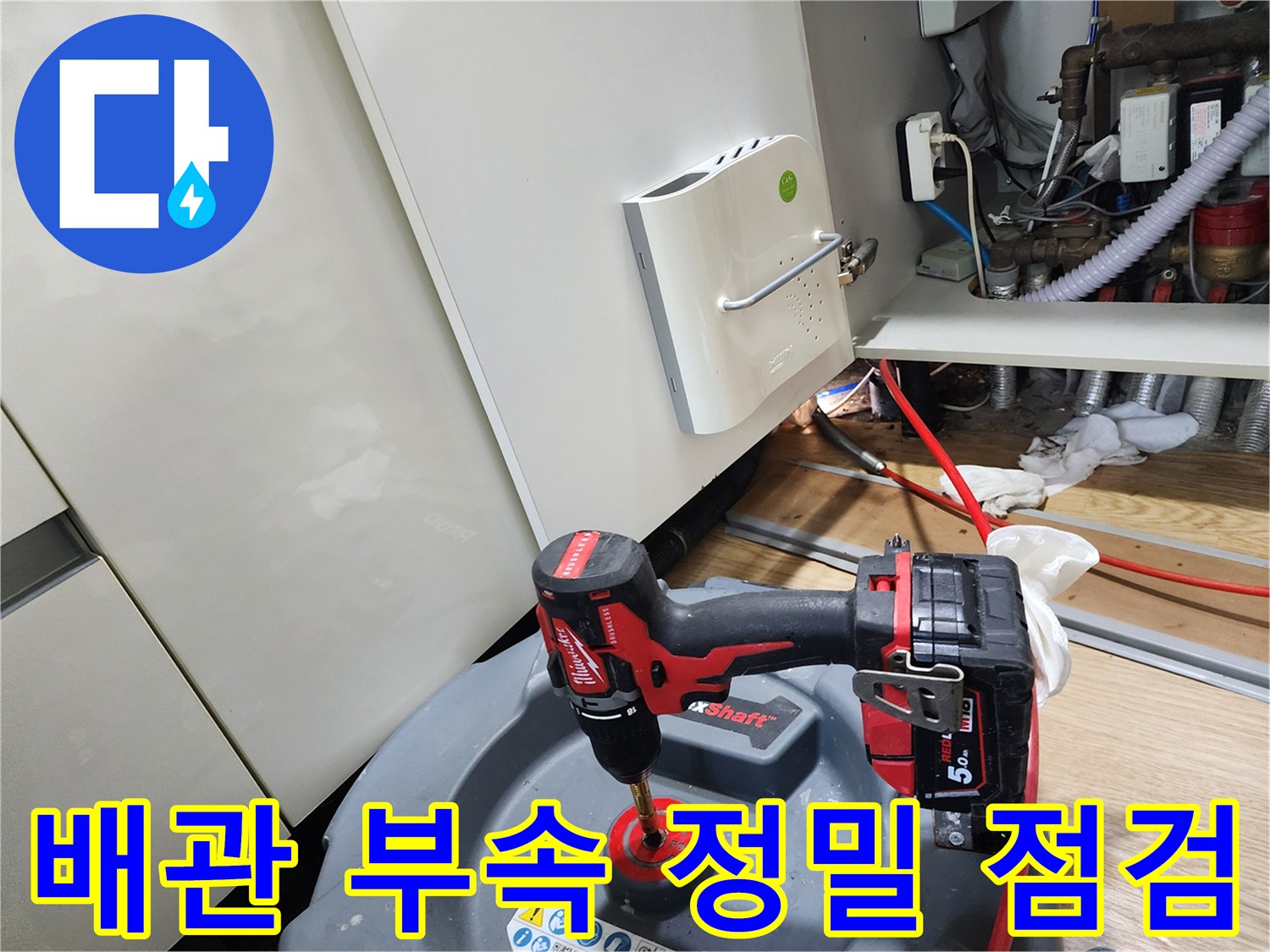 싱크대 아래 배관의 누수 지점을 찾기 위해 공구를 사용하는 모습