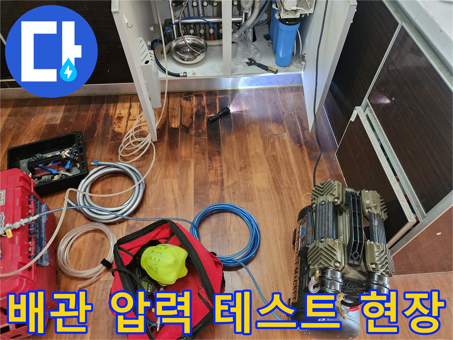싱크대 배관의 누수를 확인하고자 공압 장비를 연결하여 점검하는 모습입니다.