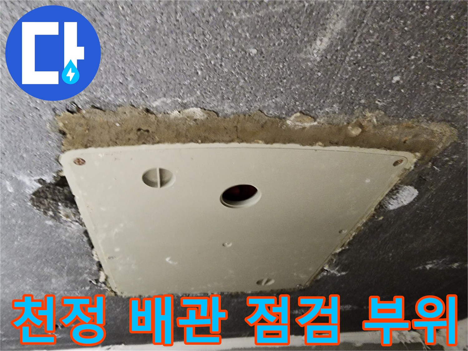 점검구 주변의 거친 마감면과 내부 배관 통로를 촬영한 사진입니다.