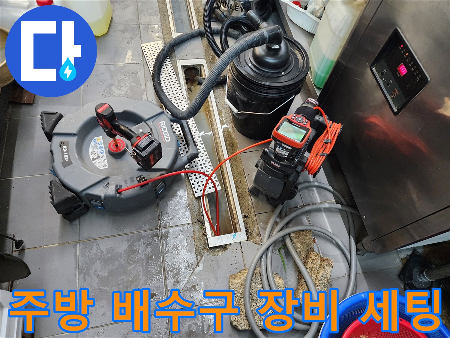 트렌치 배수구 근처에 배치된 내시경 카메라와 습식 청소기 모습입니다.