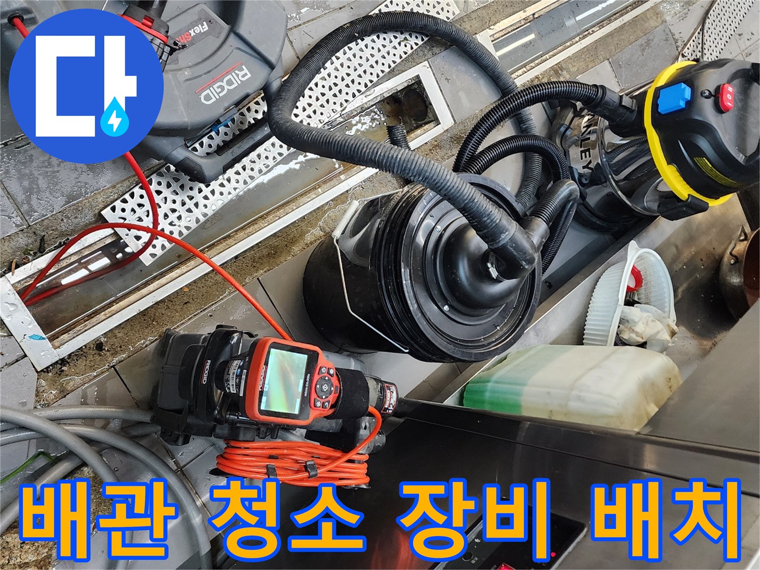 트렌치 배수구 옆에 준비된 내시경 카메라와 습식 진공 청소기